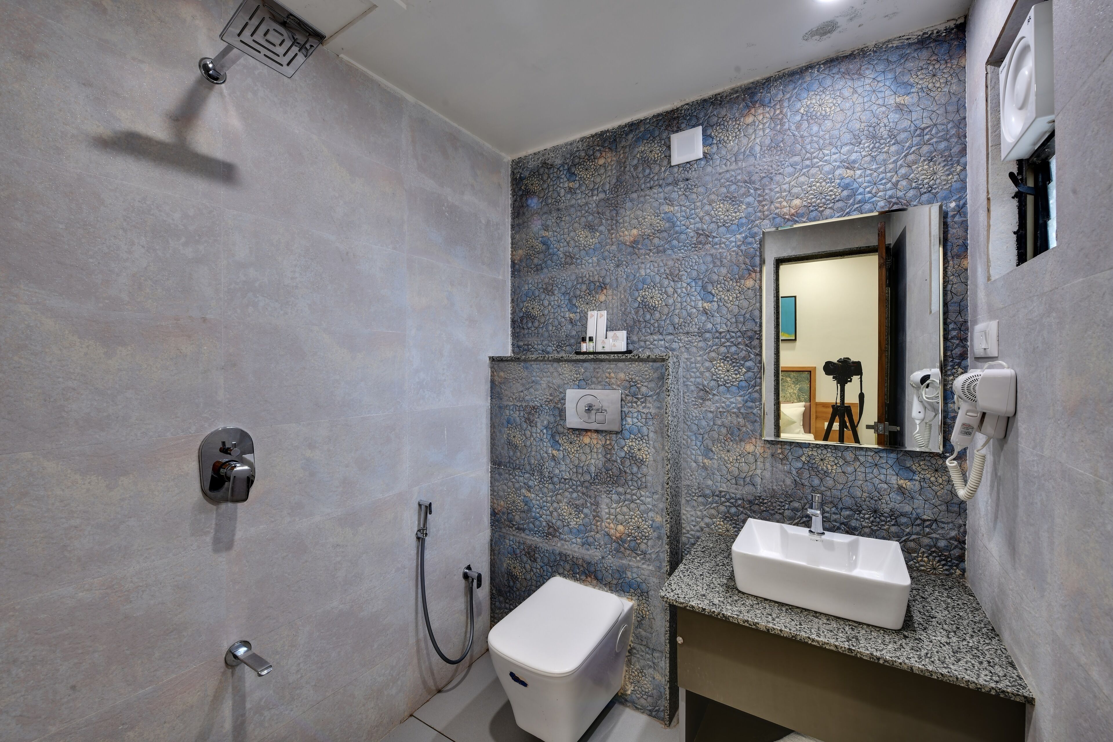 Une salle de bain équipée d’une douche, de toilettes, d’un lavabo et d’un miroir.