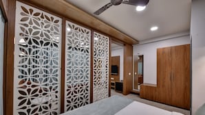 Un dormitorio con cama, armario de madera y biombos decorativos.