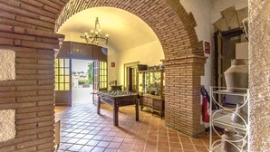 A room with a foosball table, a brick fireplace, and a chandelier.