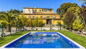 A swimming pool with a house in the background.