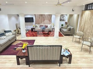 A modern living room with a sofa, a coffee table, and a TV mounted on the wall. - My petite bed and breakfast  (Kumasi)