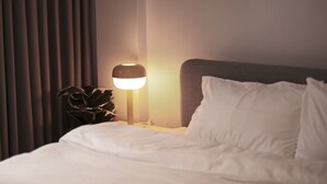 A neatly made bed with white linens, a bedside lamp, and a potted plant on the nightstand. - 4 Bedrooms, Private&Cozy @ Walking Street (Chang Wat Chiang Rai)
