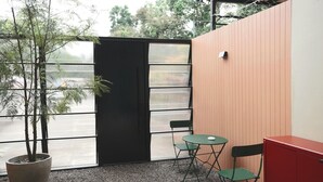 A small outdoor seating area with a table and chairs, a potted plant, and a red cabinet. - 4 Bedrooms, Private&Cozy @ Walking Street (Chang Wat Chiang Rai)