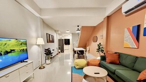 A modern living room with a flat-screen TV, a sofa, a coffee table, and a dining area with chairs and a table. - 4 Bedrooms, Private&Cozy @ Walking Street (Chang Wat Chiang Rai)
