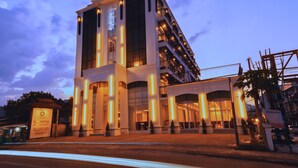 A multi-story hotel with a modern architectural design, featuring large windows and a prominent entrance. - Oudomsin VangVieng Hotel (Vang Vieng)