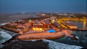 An aerial view of a coastal hotel with a pool, beach access, and a view of the sea. - Azalai Hotel Dakar (Dakar)