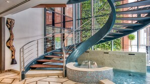 A spiral staircase leading to a rooftop pool area with a view of greenery outside. - Azalai Hotel Dakar (Dakar)