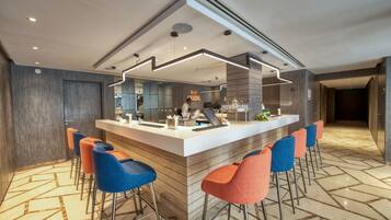 A modern bar area with a central island, bar stools, and a patterned floor.