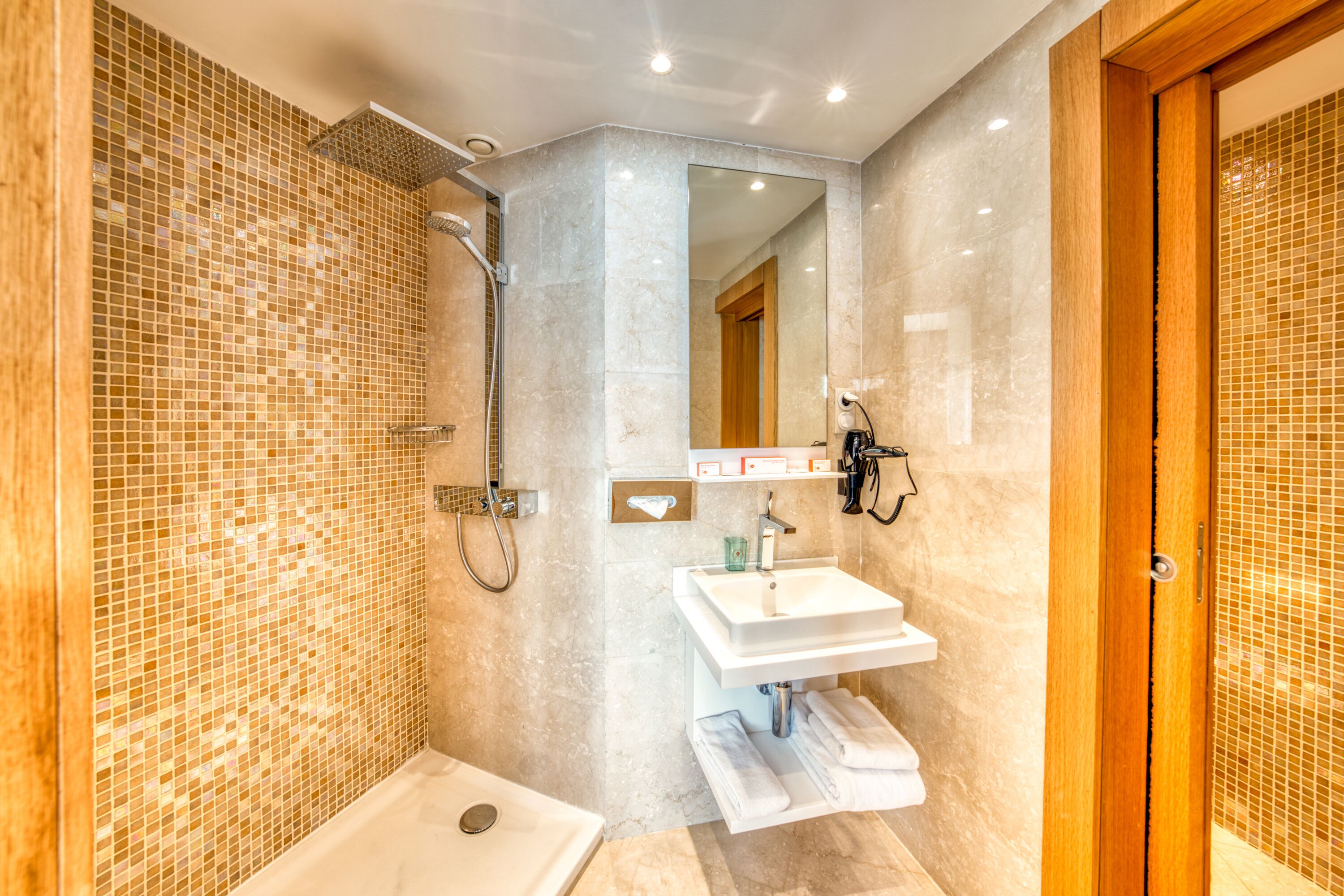 Un baño moderno con ducha, lavabo e inodoro.