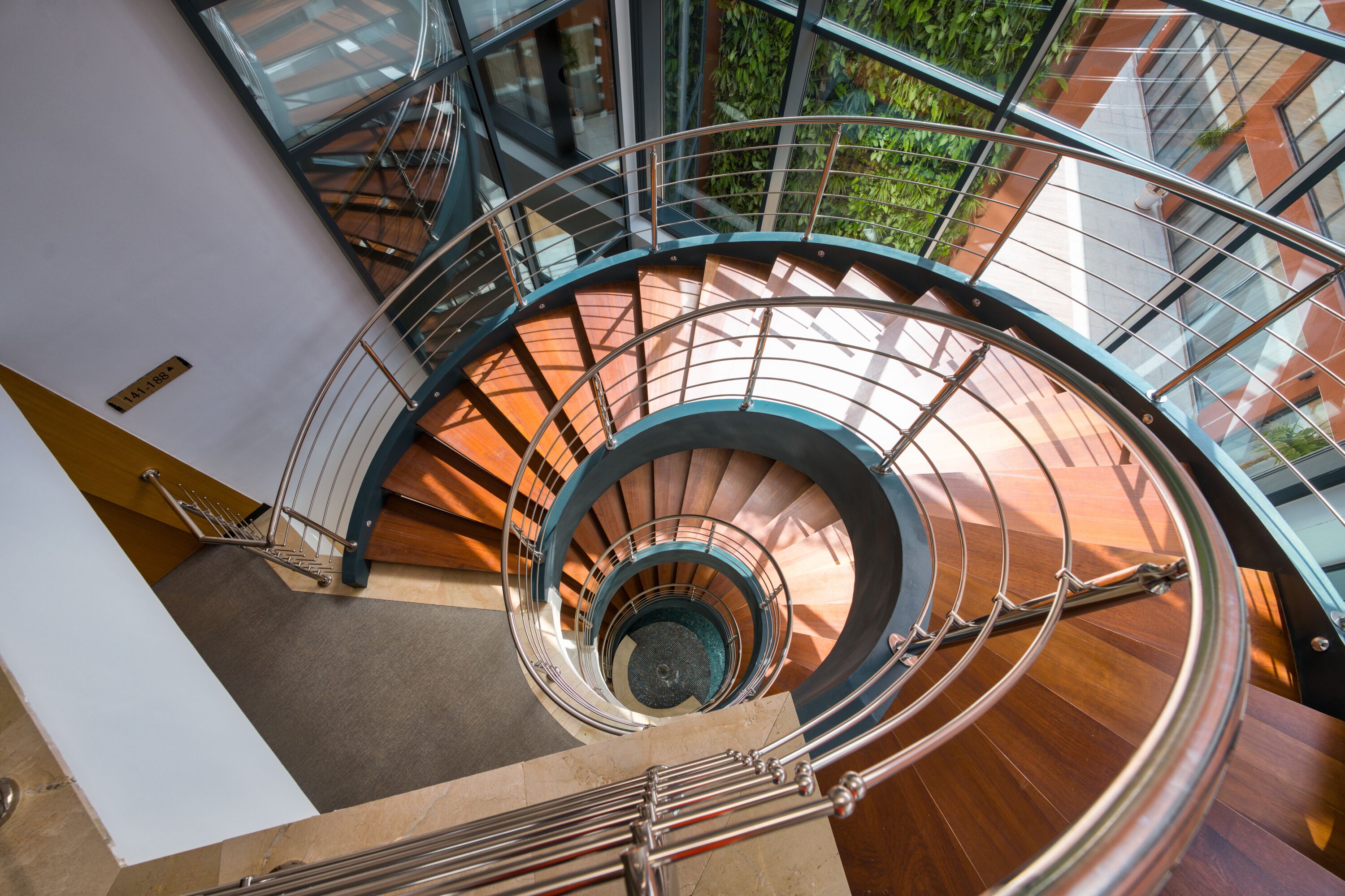 A spiral staircase with glass railings and wooden steps.