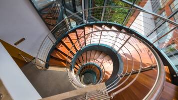 A spiral staircase with glass railings and wooden steps.