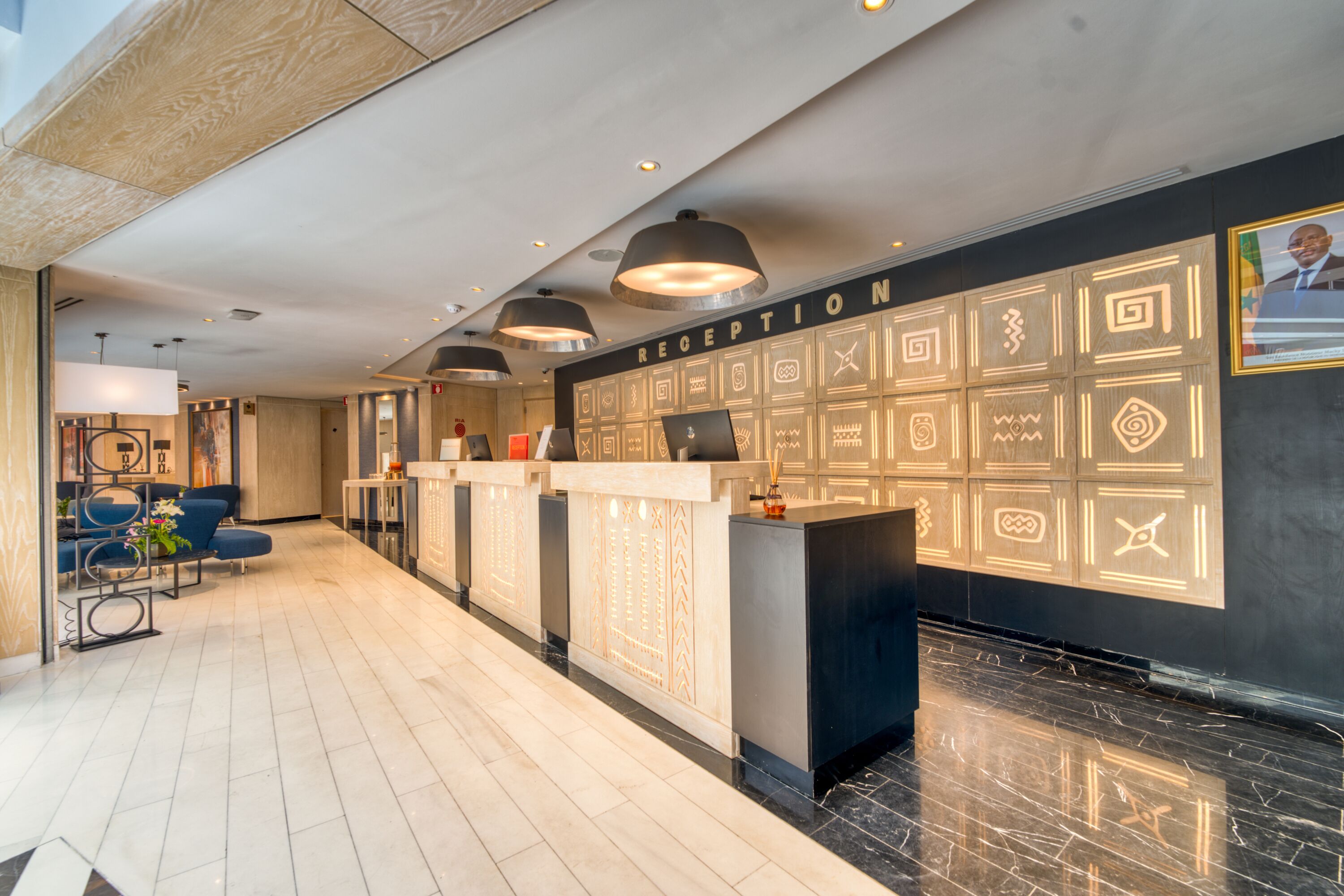A reception area with a modern design, featuring a reception desk, seating area, and a wall with decorative patterns.