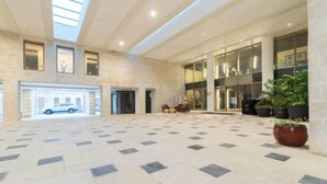 A spacious lobby with a checkered floor, large windows, and a car parked outside. - Luxurious 1BDR Terrace Parking in City Central (Jerusalem)