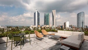 A rooftop terrace with outdoor seating, including a table and chairs, and a sofa. - w* | Stunning loft in Cuauhtemoc (Ciudad de México)