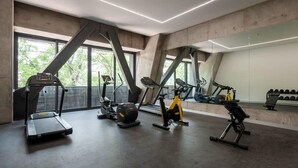 A modern gym with treadmills, an elliptical, and a stationary bike. - w* | Stunning loft in Cuauhtemoc (Ciudad de México)