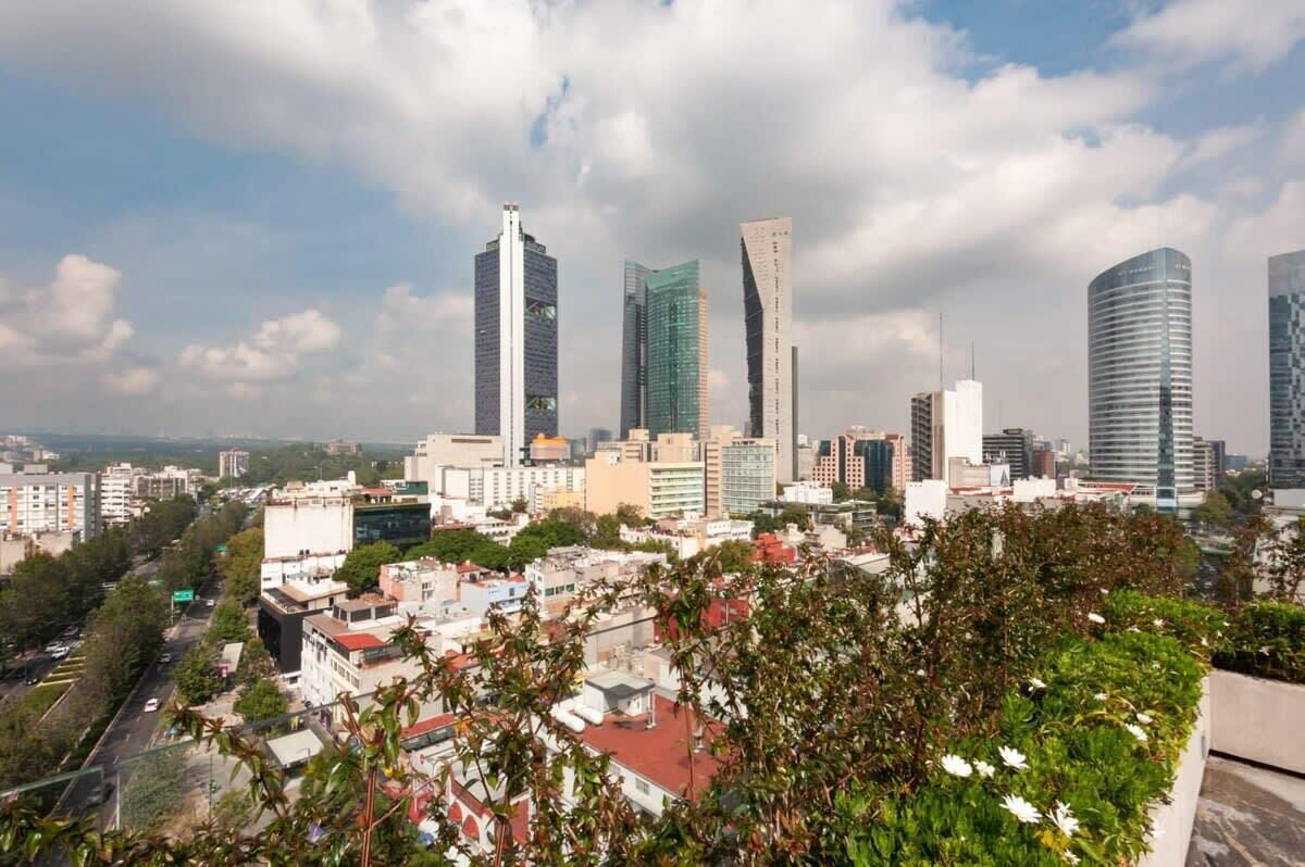 A cityscape with modern skyscrapers, a mix of residential and commercial buildings, and a clear sky.