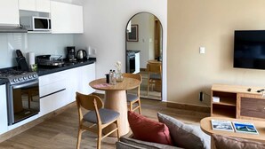 A compact living space with a kitchenette, a dining area, and a seating area with a TV. - w* | Amazing loft in Cuauhtemoc (Ciudad de México)