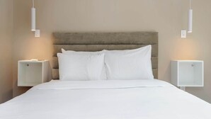 Un letto rifatto con lenzuola bianche in una camera d'albergo.