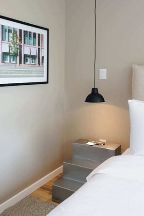 A bedroom with a bed, a nightstand, a framed picture, a pendant light, and a staircase. - w* | Vibrant 2BR with Balcony in Condesa (Ciudad de México)
