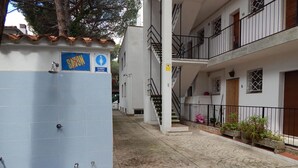 A building with a blue tiled entrance, a staircase, and a balcony with railings. - Beachside Apartment with Free WiFi, Terraces & Near Shops and Restaurants (Platja d'Aro)
