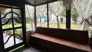 A room with a bench, a fan, and a view of the outdoors. - The Iceland Hotel Srinagar (Srinagar)
