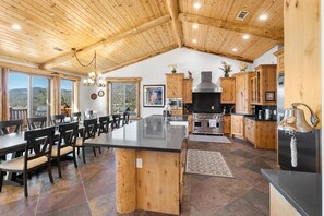 A spacious kitchen with a large island, wooden cabinets, and a view of the outdoors.