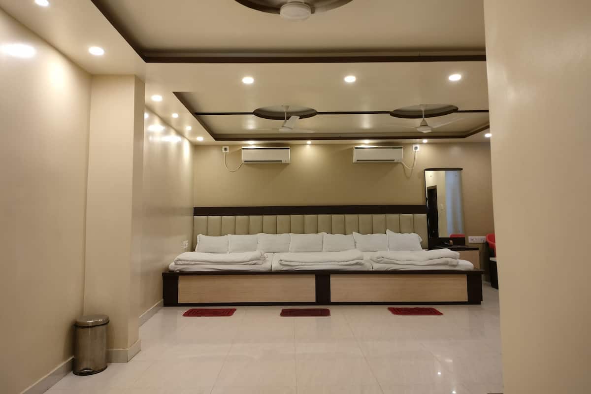 Habitació d'hotel moderna amb un llit gran, ventiladors de sostre, il·luminació empotrada i un aparell d'aire condicionat.
