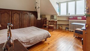 Ein Schlafzimmer mit einem hölzernen Bett, einem Schreibtisch und einer Heizung.