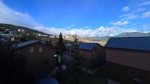 Zona residencial com casas, céu claro e montanha ao fundo.