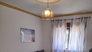 Una sala moderna con un sofá gris, una mesa de centro blanca y una mesa de comedor.