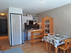 Una cocina compacta con microondas, estufa y gabinete de madera.