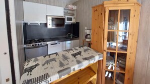 A compact kitchen with a stove, microwave, and a small refrigerator. - Studio at the foot of the slopes with balcony and pets allowed (Les Deux Alpes)