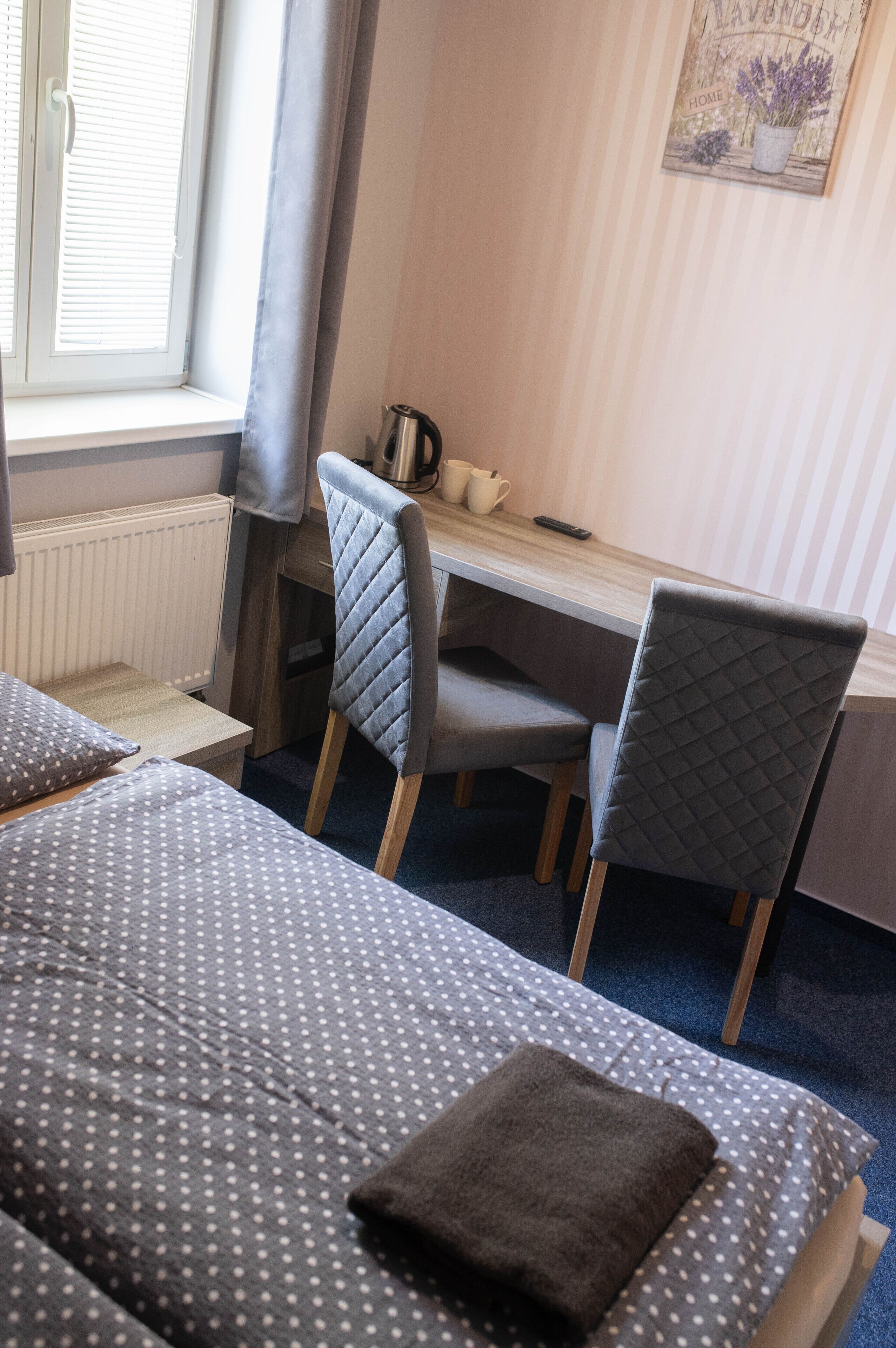 A room with two beds, a desk, and a chair.