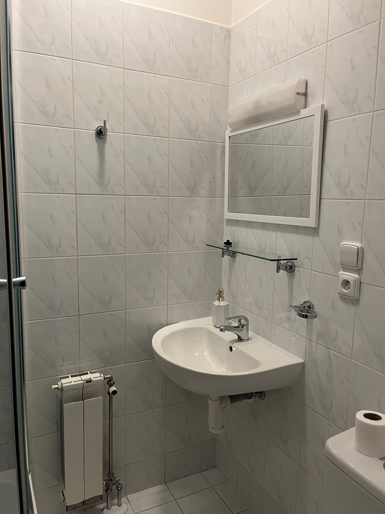 Une salle de bain moderne avec un lavabo blanc, un miroir et des toilettes.