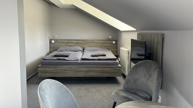 Un dormitorio moderno con cama tipo loft, una silla y un espejo.