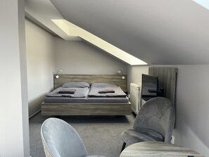 A modern bedroom with a loft bed, a chair, and a mirror. - Hotel Almond (Teplice)