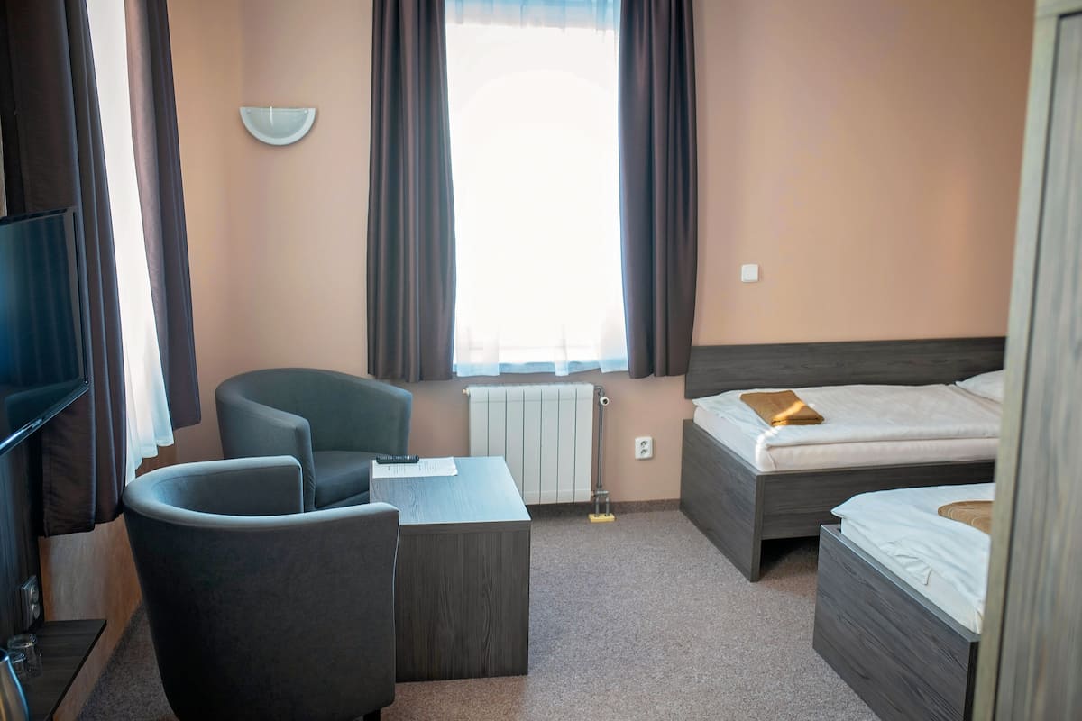Une chambre d’hôtel avec un lit, un bureau, une chaise et un téléviseur.