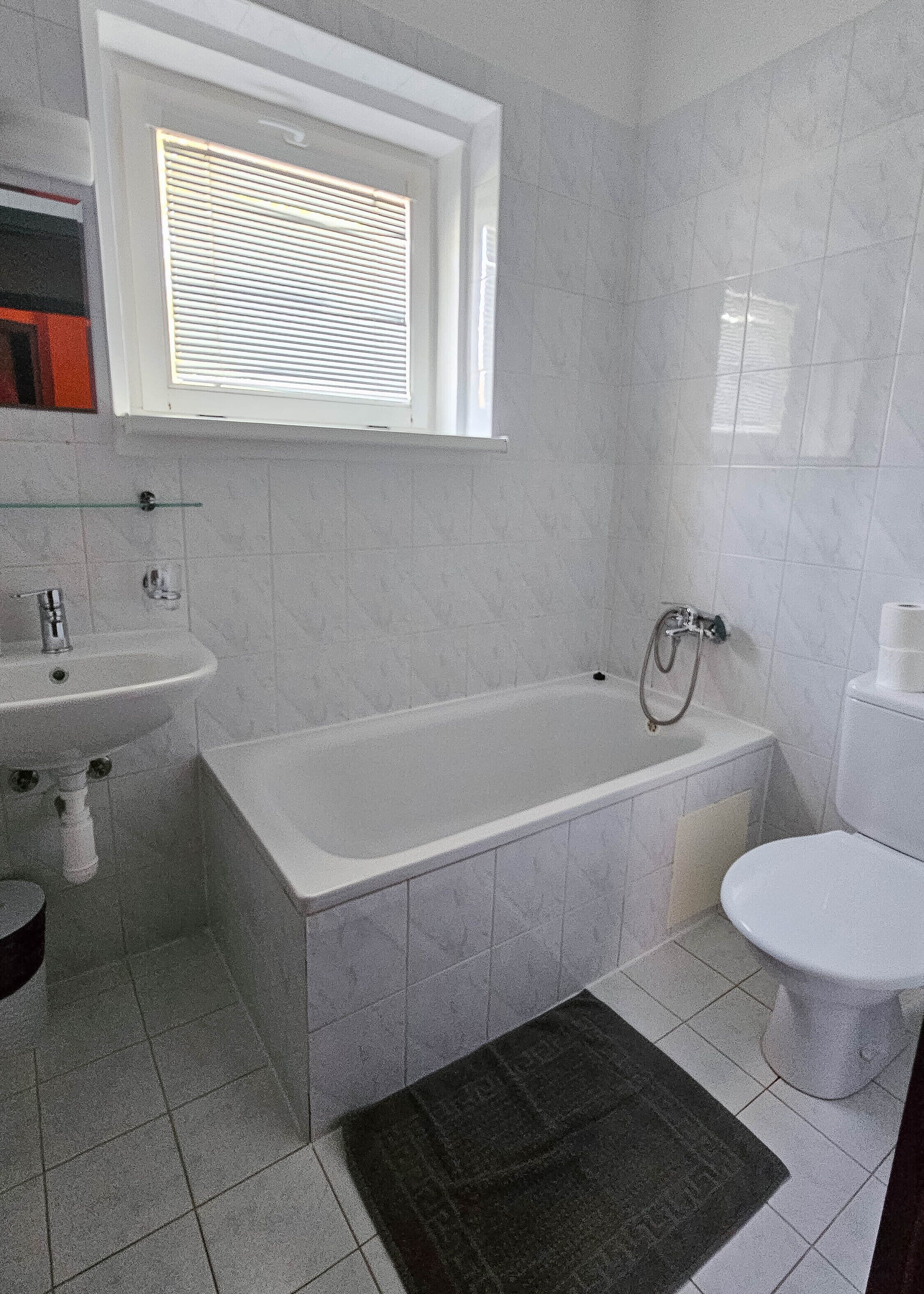 Un bagno con vasca, lavandino e WC.