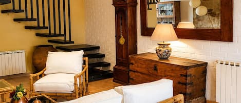 Una habitación con una escalera, un armario de madera, un reloj y una lámpara.