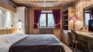 A wooden room with a bed, a desk, and a chair. - Central Megève Apartment: 3 BR, Terrace, Pet-Friendly, Near Lift (Megève)