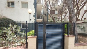A gated entrance with a metal gate and a lamp post. - Cozy Apartment with Terrace Near Beach and Shops in Costa Brava (Platja d'Aro)