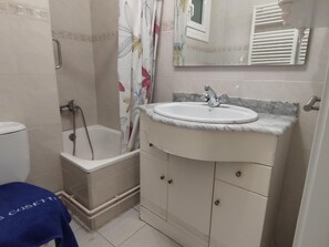 A bathroom with a bathtub, a sink, and a toilet.