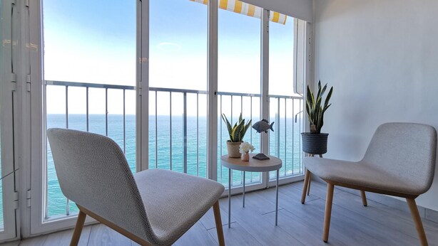A balcony with two chairs, a small table with plants, and a view of the sea. - Renovated beachfront studio with parking in Platja d'Aro (Platja d'Aro)