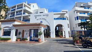 Un hôtel appelé Duquesa Suites, dont l’enseigne indique qu’il propose des installations pour la pratique du golf et dispose d’un jardin.