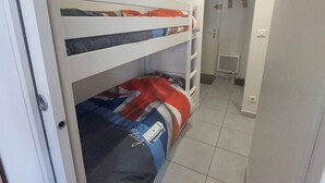 Ein Schlafraum mit Etagenbetten und einer Tür zu einem Badezimmer.