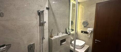 Een moderne badkamer met een douchecabine van glas, een wastafel en een toilet.