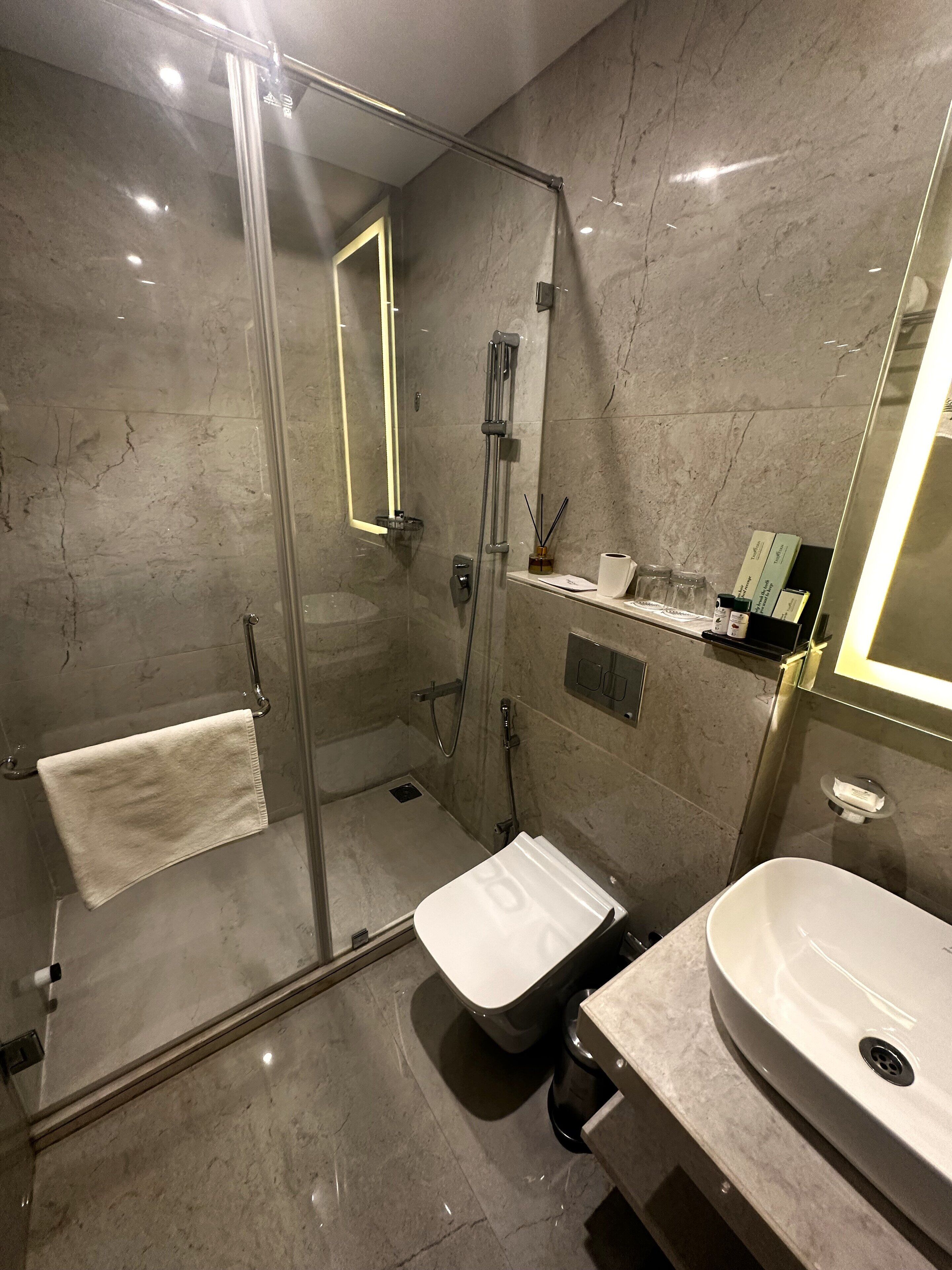 Un baño moderno con ducha envuelta en vidrio, inodoro y lavamanos.
