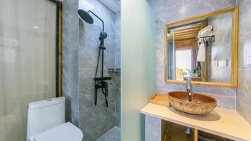 Une salle de bain moderne équipée d’une douche, de toilettes et d’un meuble-lavabo avec un lavabo en cuvette et un miroir.