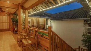 A traditional Japanese-style room with wooden furniture and a view of the outside. - yunchengyijing (Lijiang)