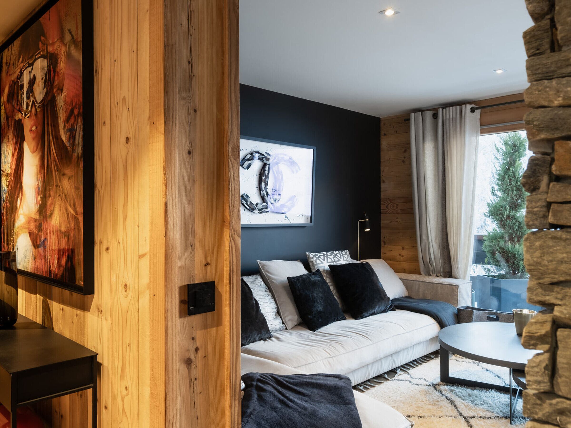 Een moderne woonkamer met een bank, een salontafel en een groot schilderij aan de muur.